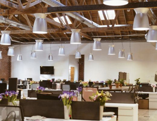 An office space with many bouquets on desks.