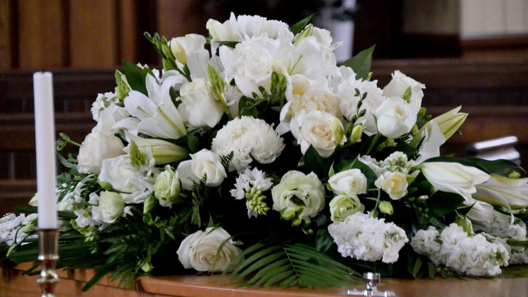 funeral casket flower arrangement with white flowers