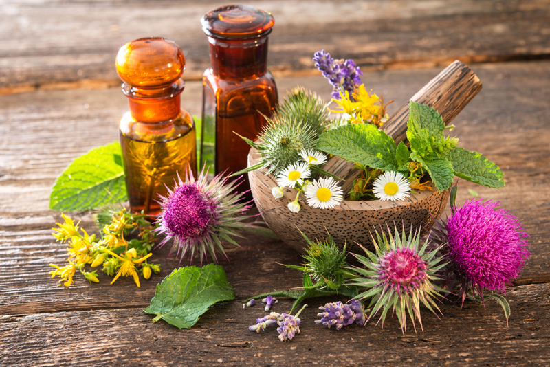 flowers with tincture bottle and wood mixing bowl