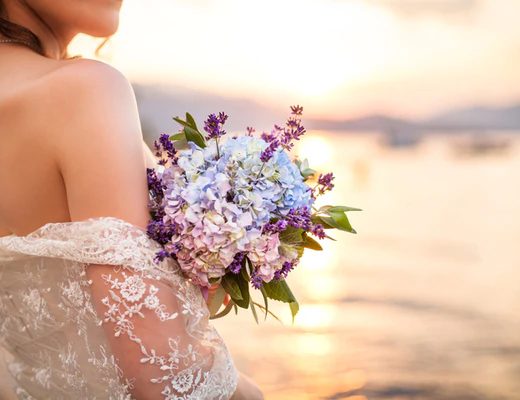 hydrangea wedding bouquet held by a bride with sunset in background