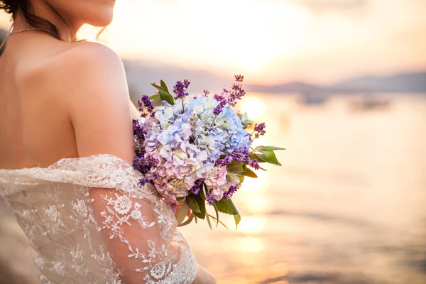 hydrangea wedding bouquet held by a bride with sunset in background