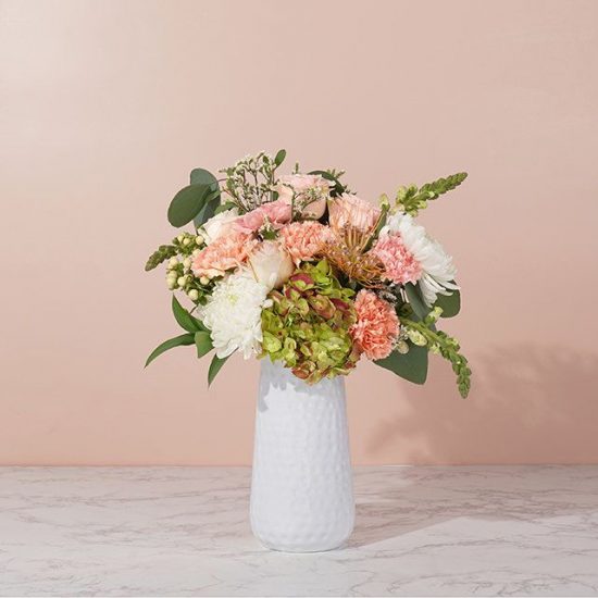 bouquet in a vase with hydrangeas, spider pin cushion and pink roses
