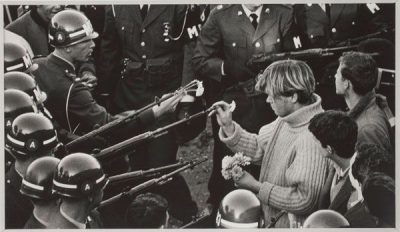 Vietnam protester putting a flower in a rifle