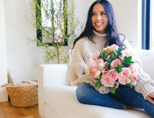 Woman on coach with valentine's day flowers.