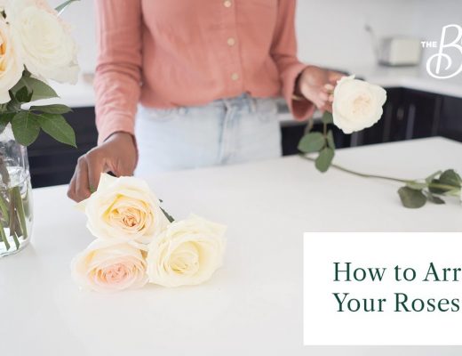 Woman in the process of arranging white roses.