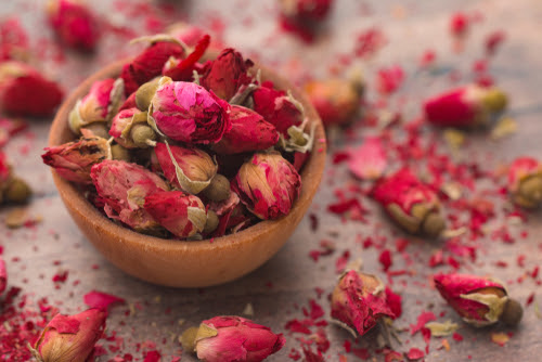 Dried Pink Rose Buds in a Brown Bowl