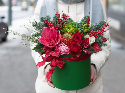 beautiful Christmas floral arrangement in a hat box in shades of red, burgundy and green