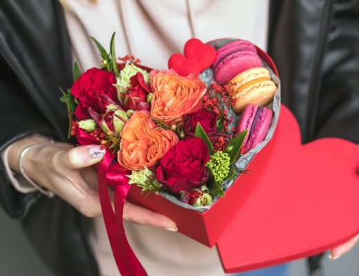 Red and orange flowers in a heart shaped hat box for valentines day