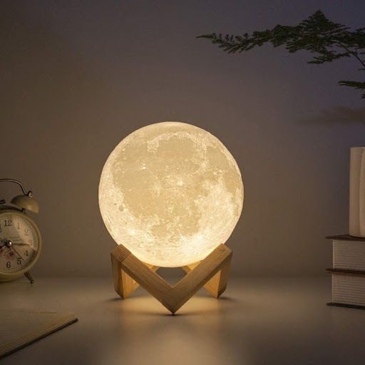 spherical lamp that looks like the moon on a wood stand