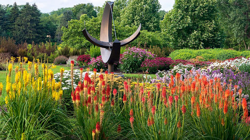 orange, red, and yellow flowers and a tall sculpture at Chicago botanical garden