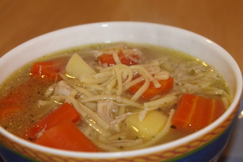 bowl of chicken noodle soup with large carrot chunks in it