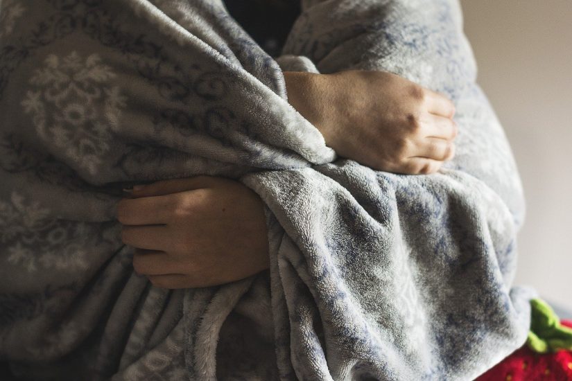 person wrapped up in a fuzzy gray blanket