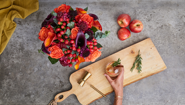 flower bouquet in burgundy, orange and re with a food platter