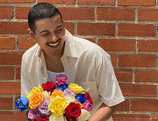 smiling man holding multi-colored roses bouquet