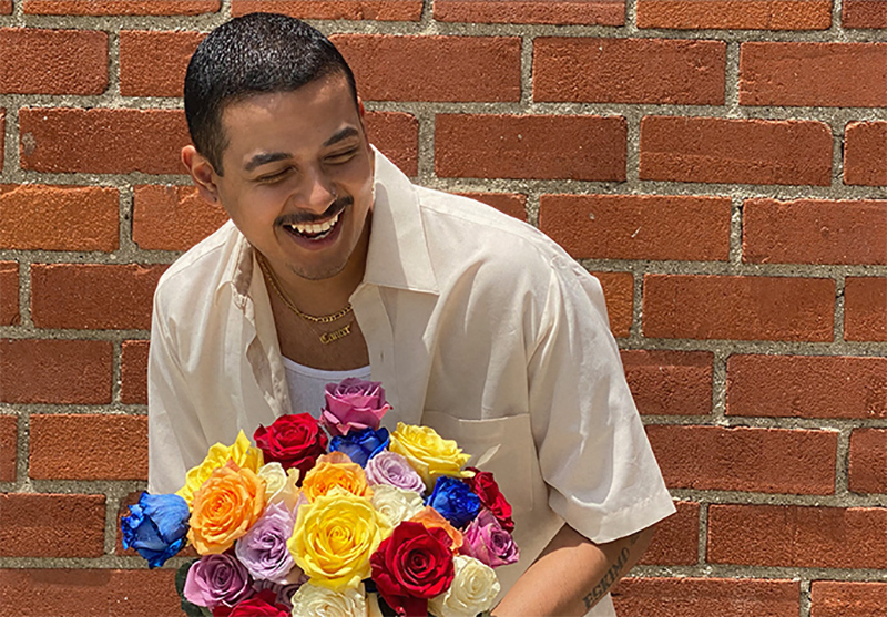 smiling man holding multi-colored roses bouquet
