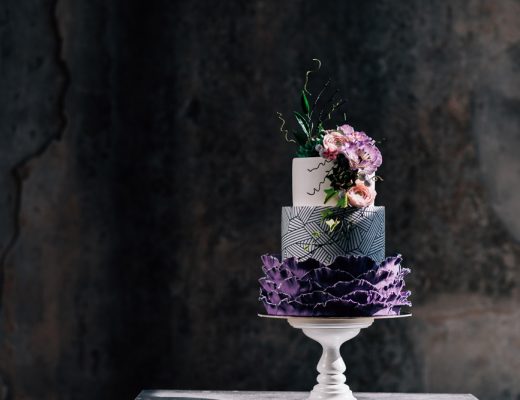wedding cake in purples and dark tones with flowers decorating it