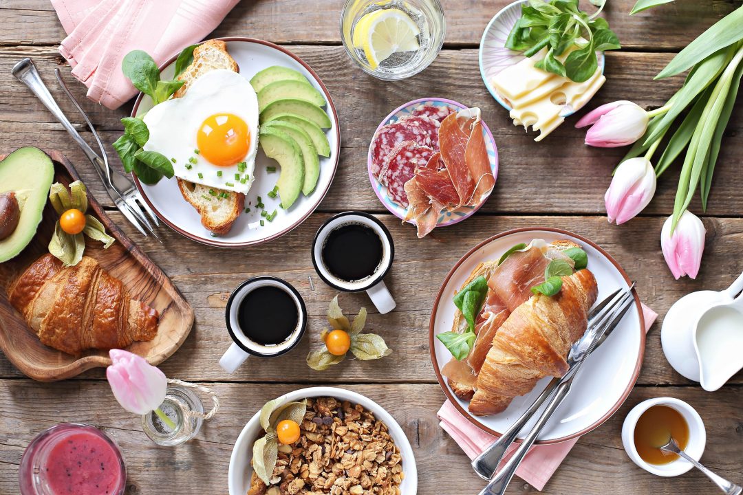 Brunch spread with pink tulips features on the table