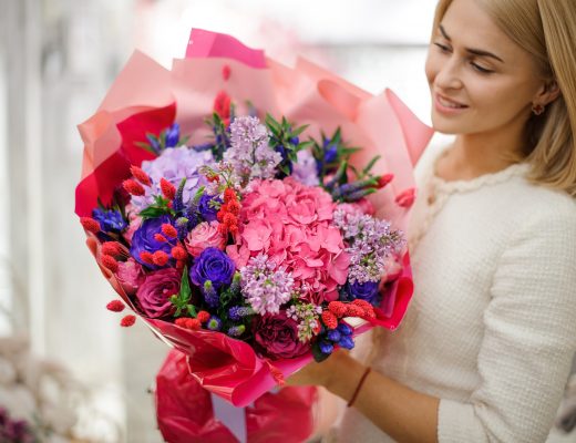 Young woman holding a bouquet of flowers, including hydrangeas