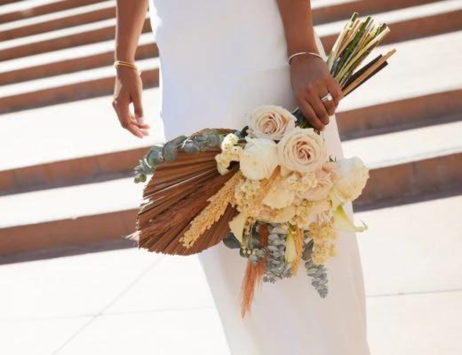 Bride holding bouquet of dried flowers at her side