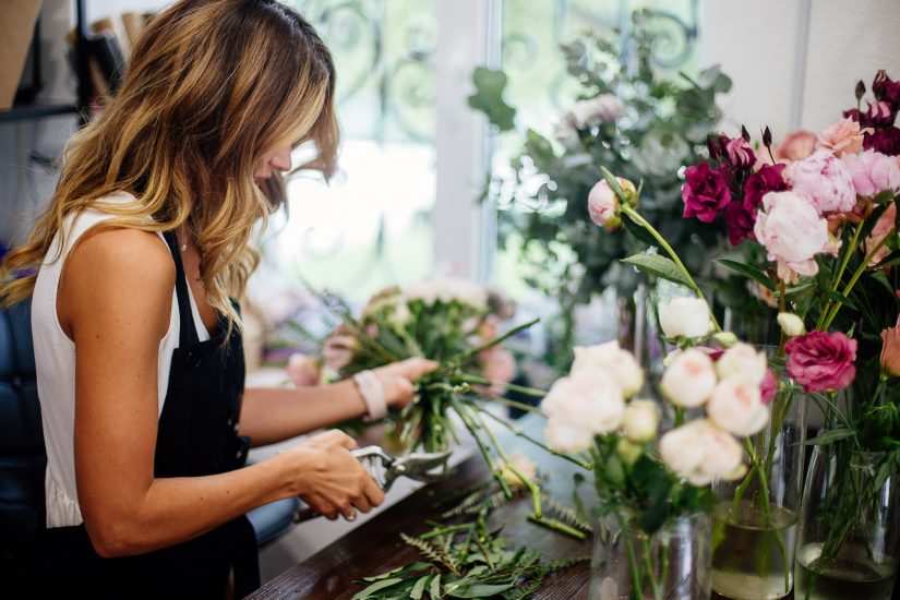 Florist trimming flowers for a bouquet in store
