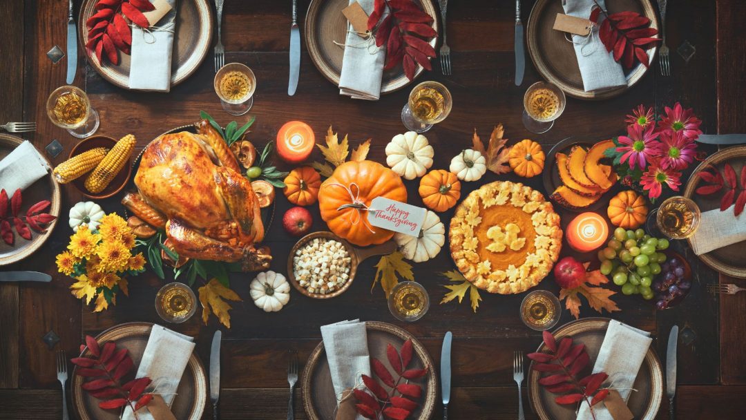 A Thanksgiving dinner table arranged with food and plates