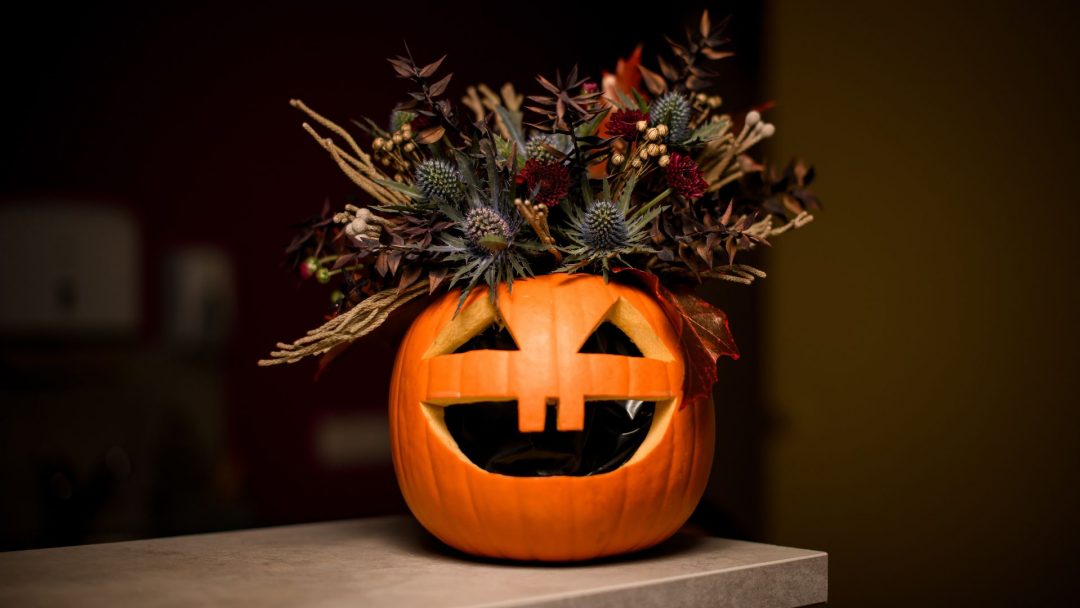 Jack-o-lantern filled with dark flowers for Halloween