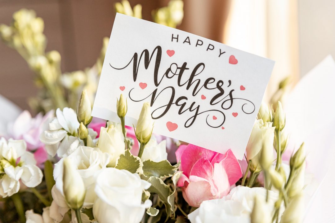 A card reading "Happy Mother's Day" sits in a bouquet of flowers