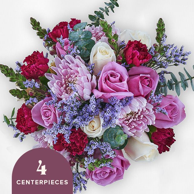 4 centerpieces with purple floral blooms.