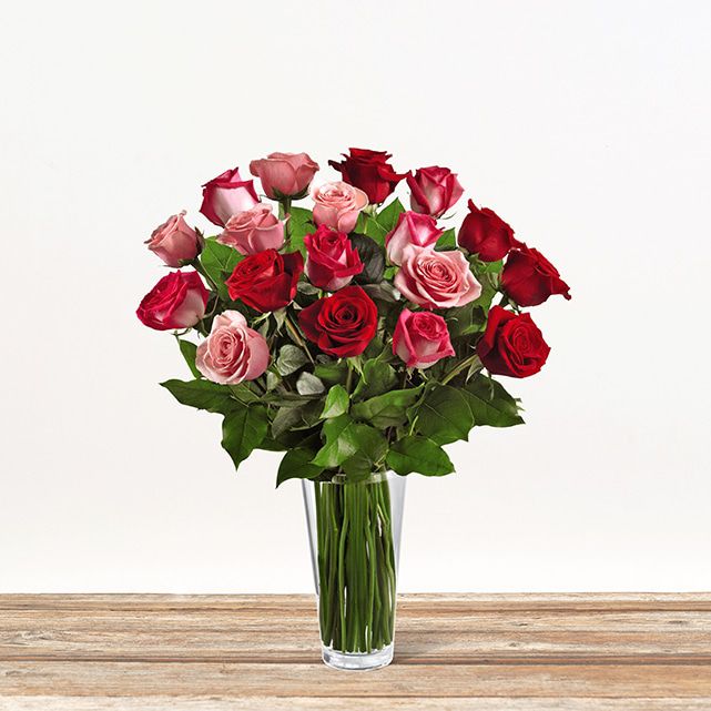 Floral arrangement with red, fuschia, and pink flowers.