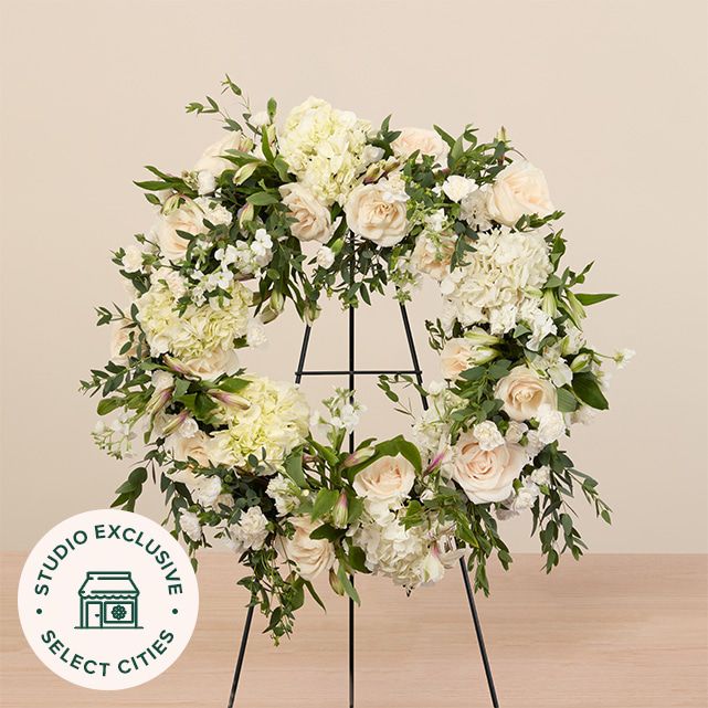 mixed floral wreath in white with roses, hydrangeas, and lush greenery