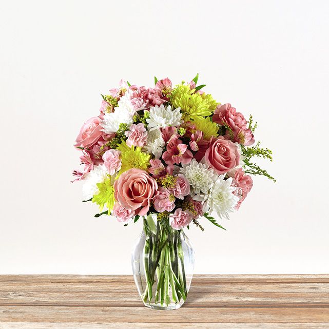 Pink focal flowers with white and yellow accents and greenery.